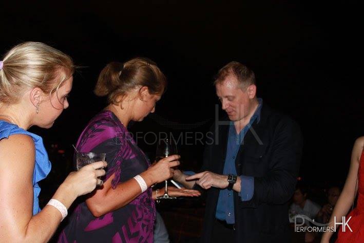 Shaun the magician shows guests tricks at a cocktail party in Hong Kong