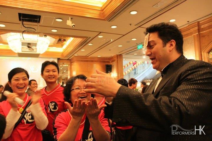 magician performing roving card magic to runner at the Li & Fung Standard Chartered Hong Kong Marathon after party in Regal Hotel