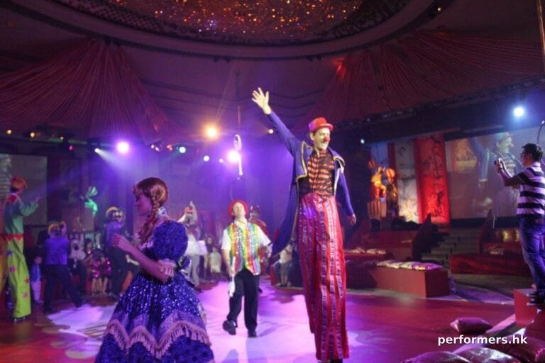 Stiltwalker and juggler and pretty girl in parade in the Hyat Hong Kong ballroom