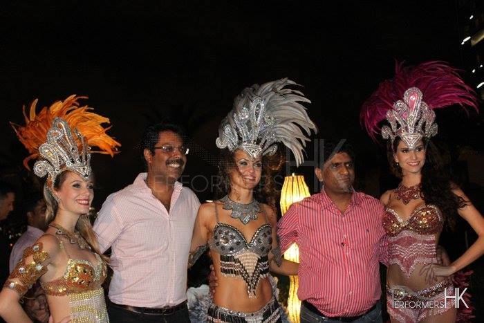 Two Indian business men standing with three Brazilian Dancers