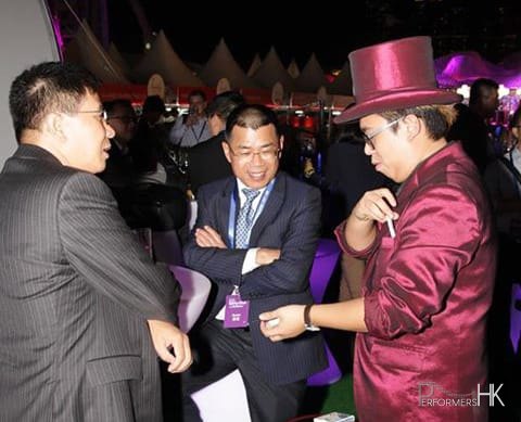 Walk-around magician performing to two gentlemen at a race meet in Hong Kong