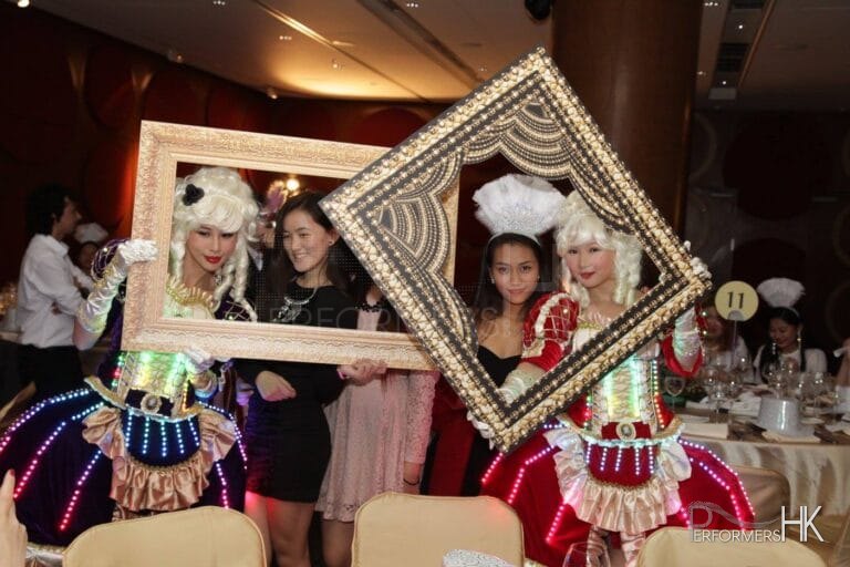 Two pretty girls wearing courtesan style costume with LEDs and having pictures taken with large photos frames