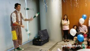 Roving juggler in HK juggling three cups at a corporate xmas event