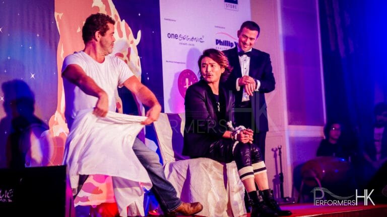 HK magician performing stage escape magic , and one of the audience helper is going to cover a white cloth at a corporate annual dinner