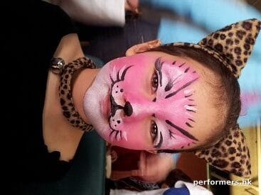 A face painter form HK drew a pink kitten face paint for a girl at a animal themed party.