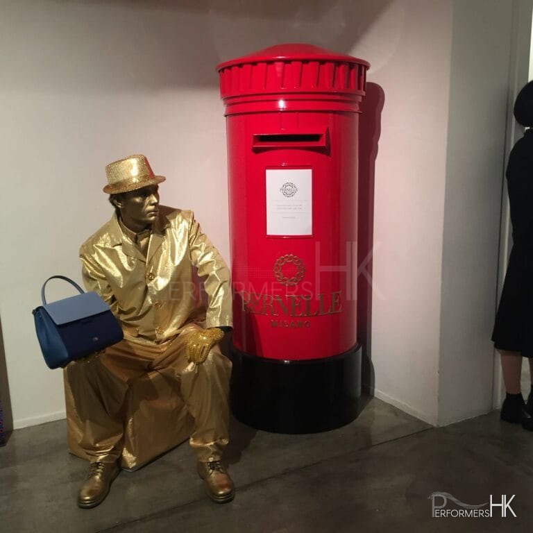 Living Statue holding handbag sitting next to red post box in hong kong