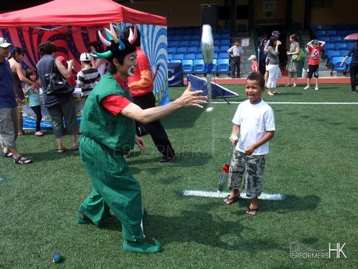 Clown with face makeup dressed at an Elf doing a juggling trick performance in Hong Kong