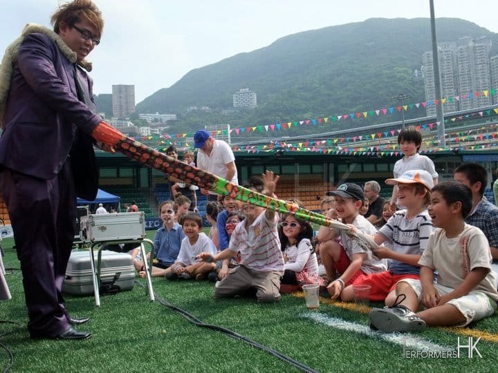 Hong Kong Magician performing with the magic glove , and the kid is trying to pull that off at a Corporate family day