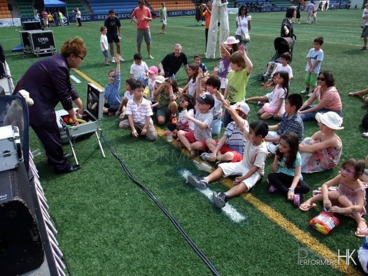 Hong Kong Stage magic entertainer ask one of the audience to be his assistant and lots of kids have put the hand up and wish to be choose at corporate family fun day