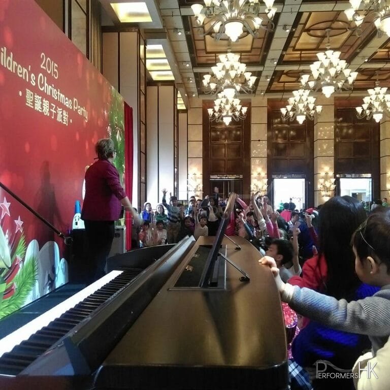 Magician in HK is performing stage magic and choosing one child from the audiences to assist his next performance at a corporate Christmas family day party
