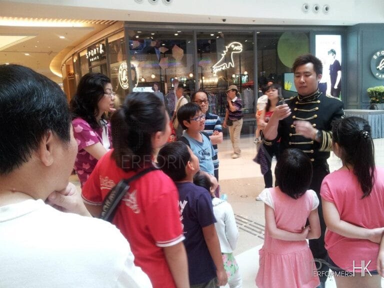 Roving Magician performing spoon bending magic to children at Hong Kong Popcorn Mall store opening event