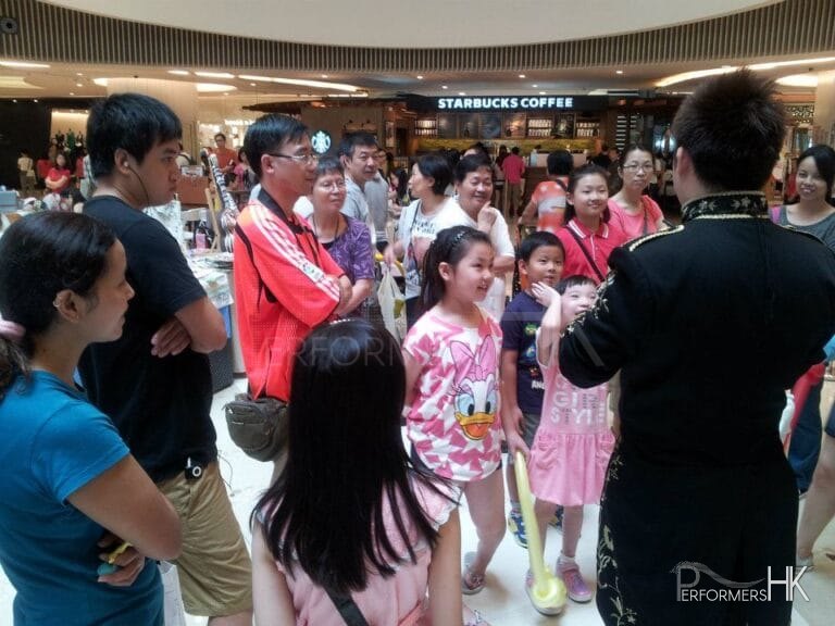 Magician with crowd around him at shopping mall