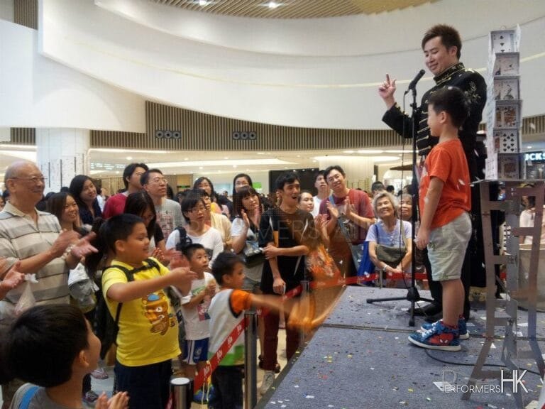 Magician performing stage magic with a volunteer at a corporate event in Hong Kong Popcorn mall