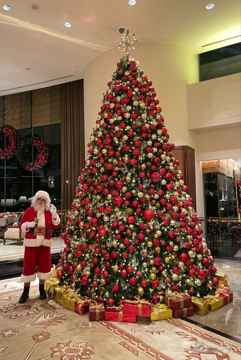 Santa Martin standing in front of a Giant Christmas Tree at Conrad Hotel in Hong Kong, a five star hotel, where he is performing Santa Clause in Hong Kong 2024 December