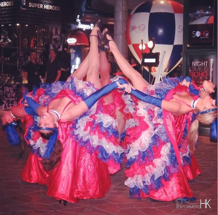 4 can can dancers lifting leg and pointing to sky together