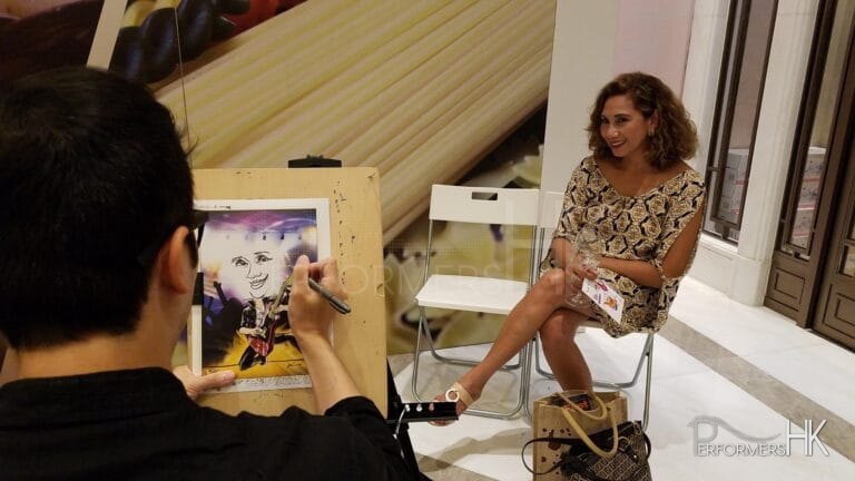Lady getting her pic drawn by caricaturist