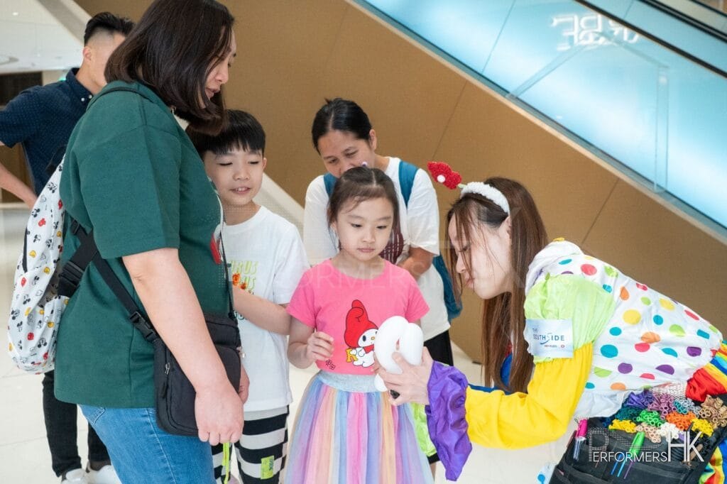 Cory making a baloon for a young shopper