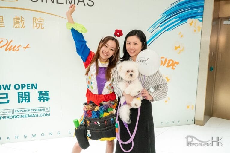 Cory with a shopper holding a dog taking a picture holding her hand in the air