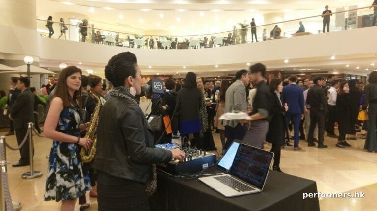 duo with lap top mixer and dj console. Pioneer djm 900, with mics and people at cocktail event