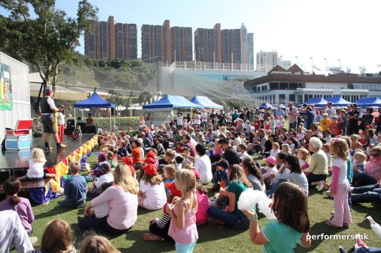 Magician Juggler at the Hong Kong cricket club doing a stage with a huge family crowd seated in front