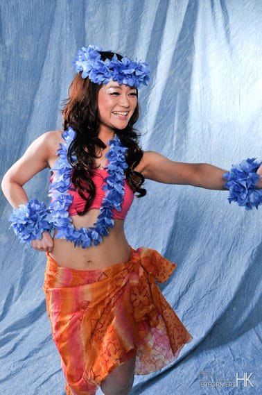 Hula dancer doing basic hula move in bright costume