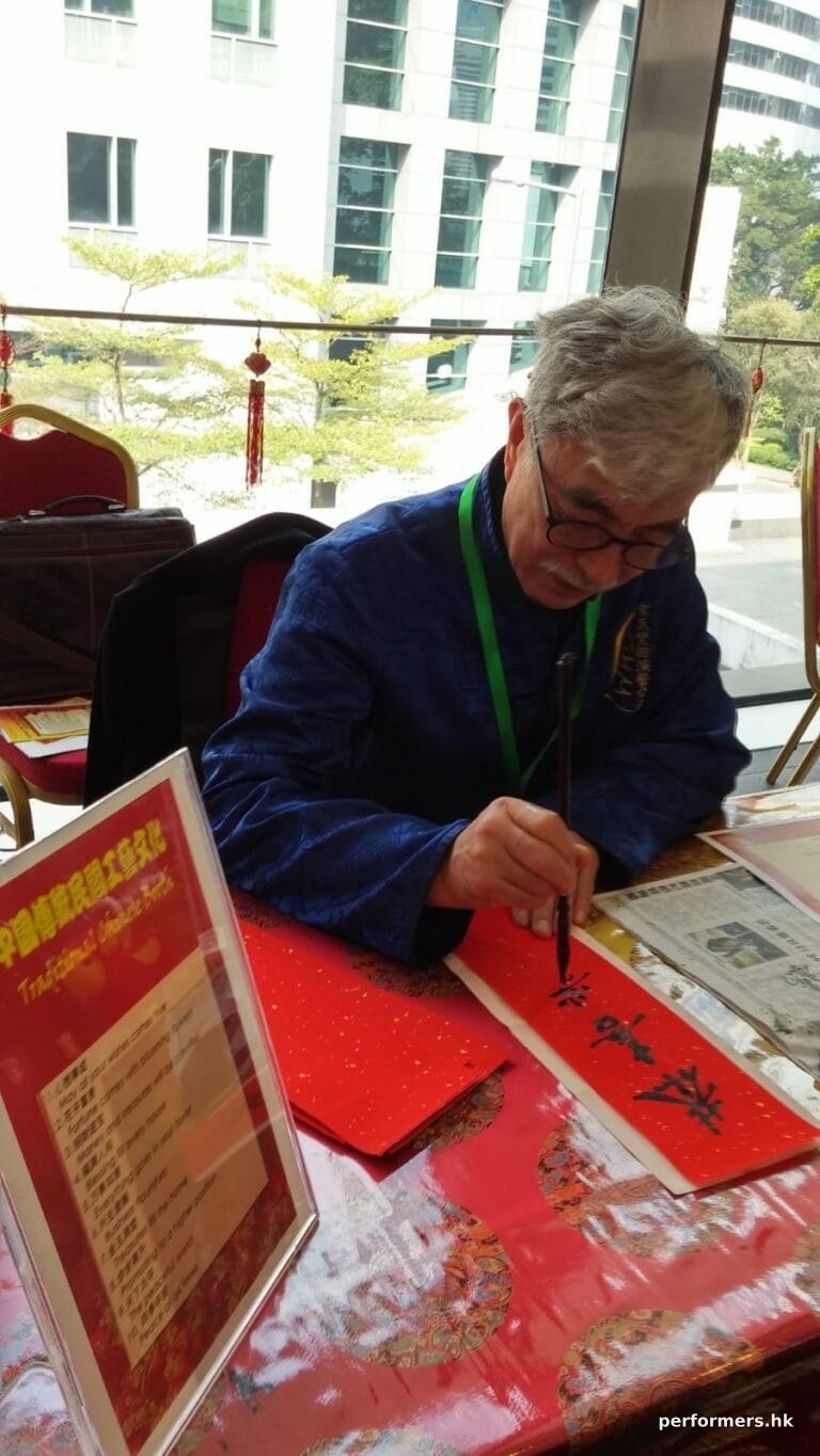 artist in blue costume working on chinese arts and craft in hong kong