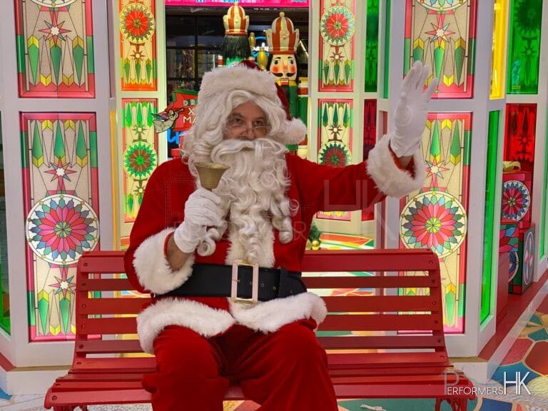 santa in red costume waving at guests
