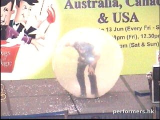 Hong Kong talented clown climbing inside a giant balloon at a shopping mall event.He is the only one to do this act in HK