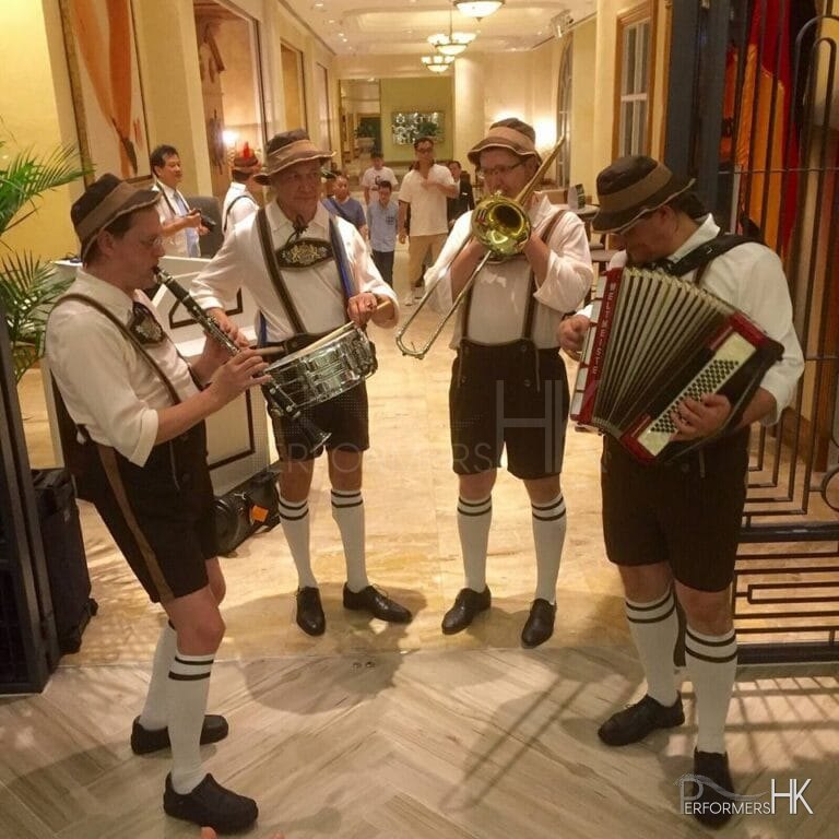 oktoberfest band playing music in a laderhosen and full outfit with accordion and brass section