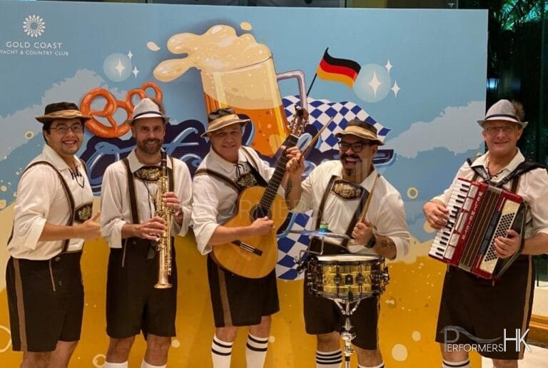 Band members jolly standing in front of a backdrop for oktoberfest for goald coast in tuen mum, hong kong