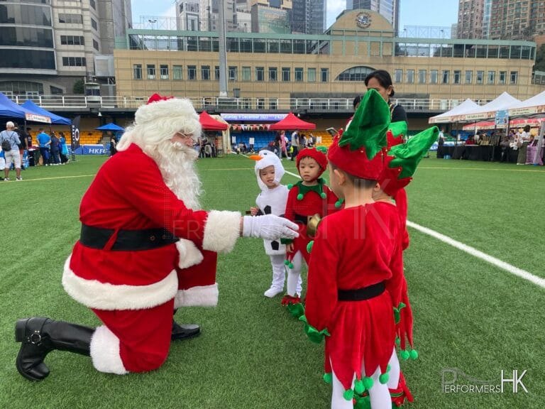 santa shaking hands with children in elf costume with snowman costume kids, greeting