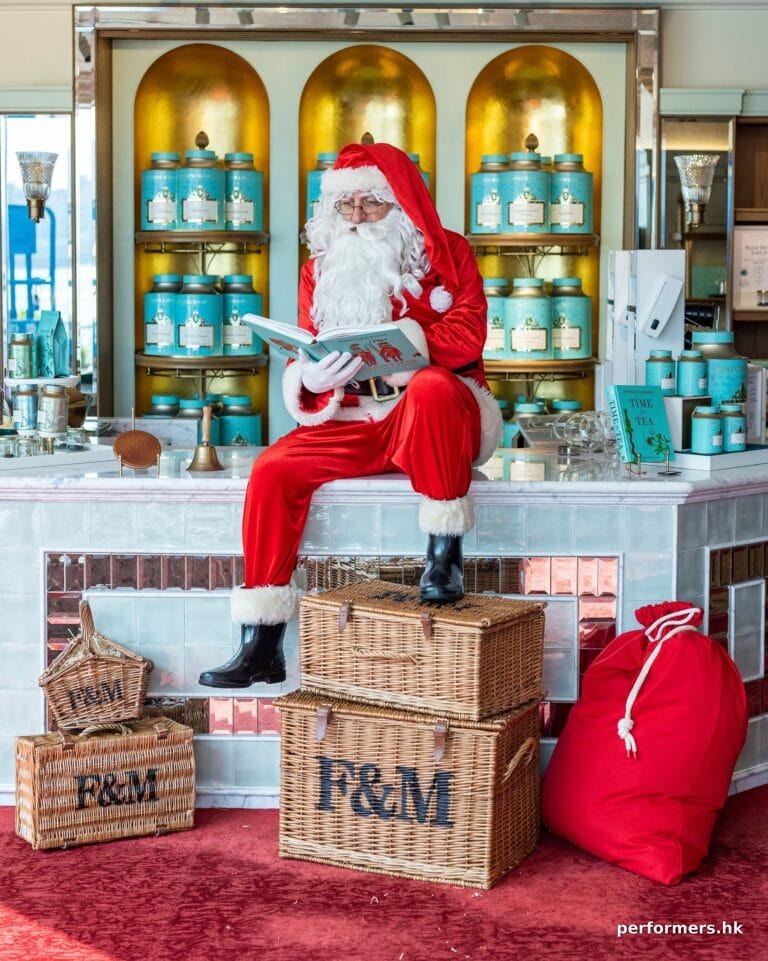 Hugh Santa sitting on counter reading a book