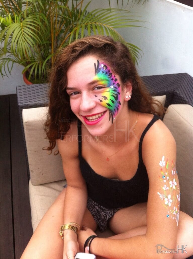 The lady is showing off her new rainbow color peafowl pattern face paint which draw by a HK talented face painter at a corporate function