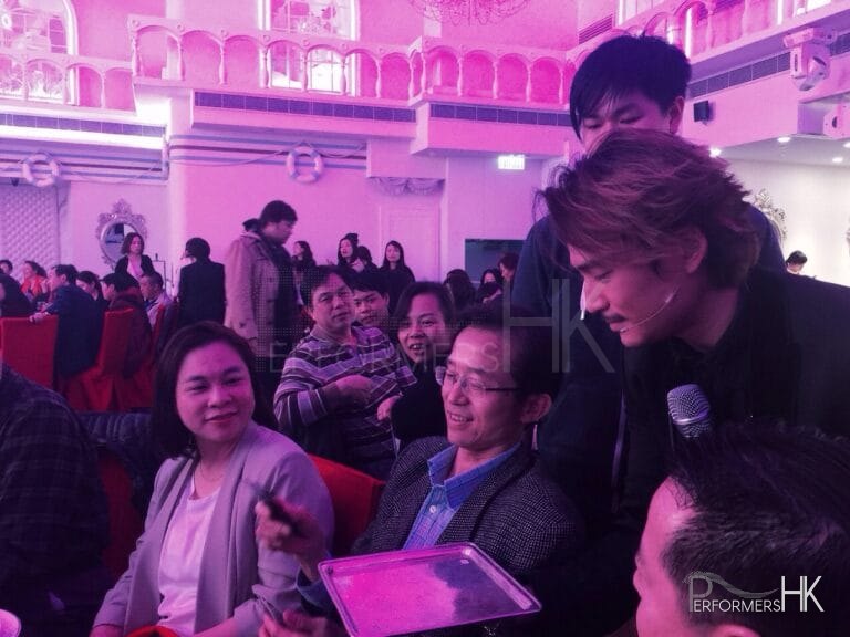 Hong Kong magician is is borrowing a mobile form the gentlemen to finish his stage magic at a corporate annual dinner