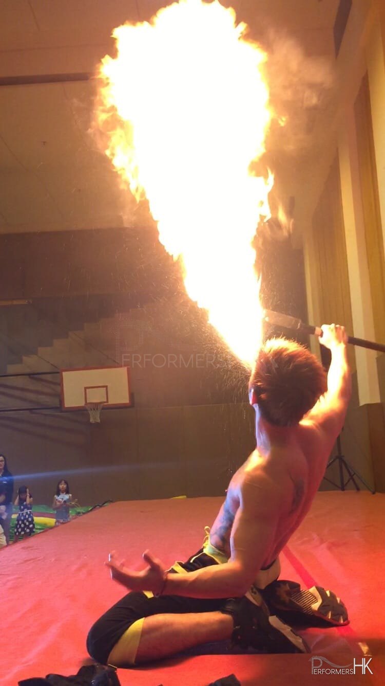 HK Fire juggler performing breathing fire act a festival event