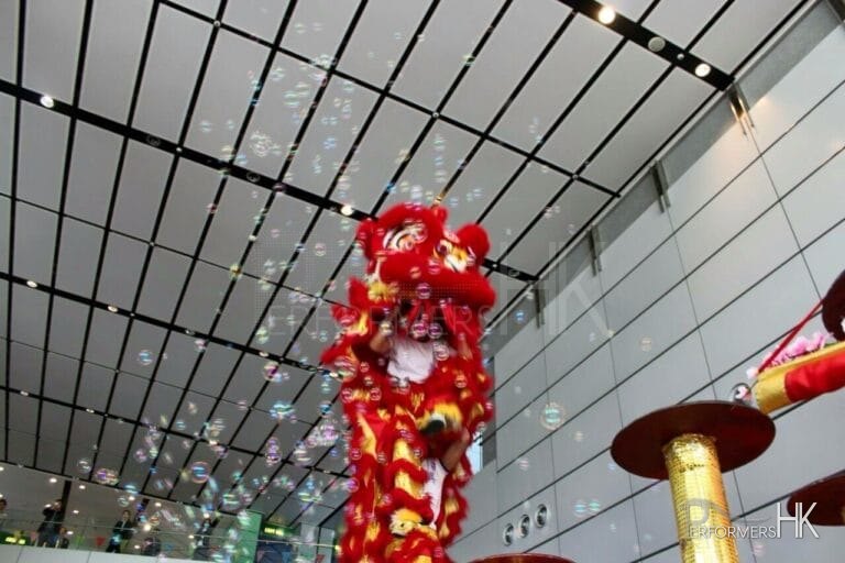 Hong Kong Dancer performing stage bubbles Lion Dance with a red lion costume at a shopping mall Chinese new year event