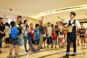 Roving magician performing coins magic at a corporate shopping mall event in Hong Kong
