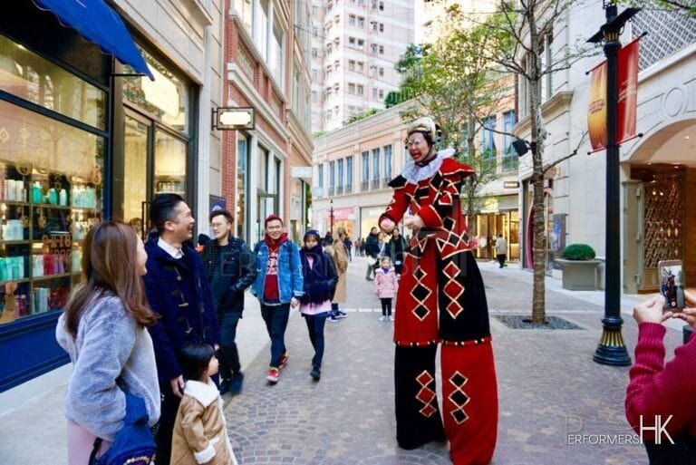 performance on the streets in stilt costume interacting with guests