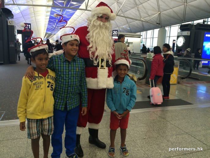 santa in red costume at the airport with kids