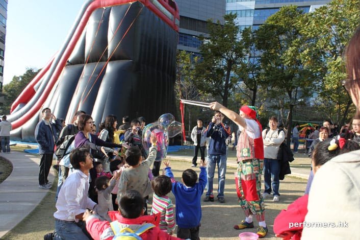 The children is trying to catch the bubbles at a Hong Kong corporate Christmas event