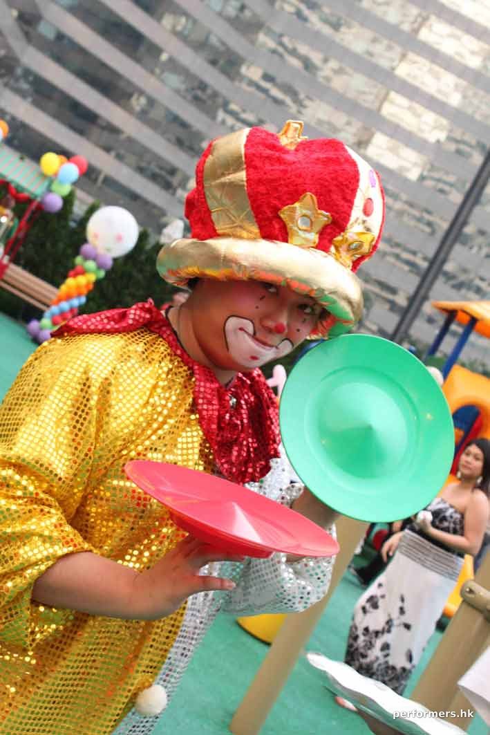 Roving juggling clown in Hong Kong posting with two juggling plates at a corporate family day