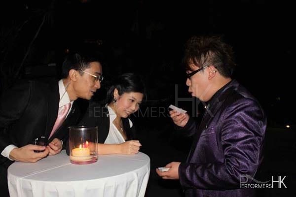 Magician in Hong Kong performing roving magic to two guests at a corporate cocktail event