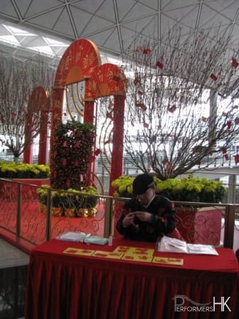 stall set up at Hong Kong Airport with craft artist doing cutting