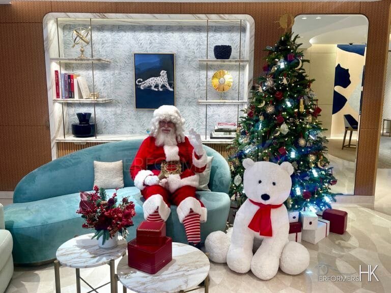Santa Martin sitting on a light blue coach at the Cartier store in Central, Hong Kong for his Santa clause performance standing in front of a small christmas tree with a big bear next to him