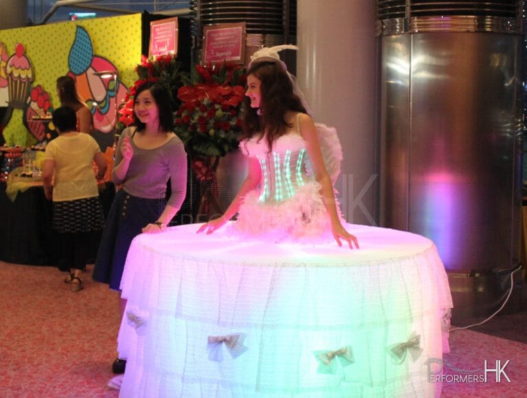 Female Model dressed as a white living table with LEDs having her picture taken