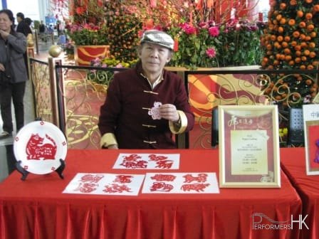 sifu wearing traditional chinese outfit cutting zodiac cuttings at hong kong airport for chinese new year