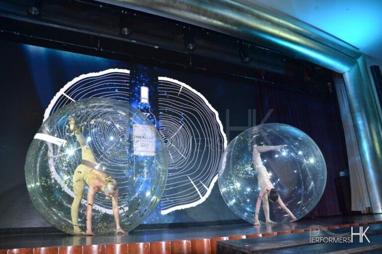 2 acrobats perform in front of blue background