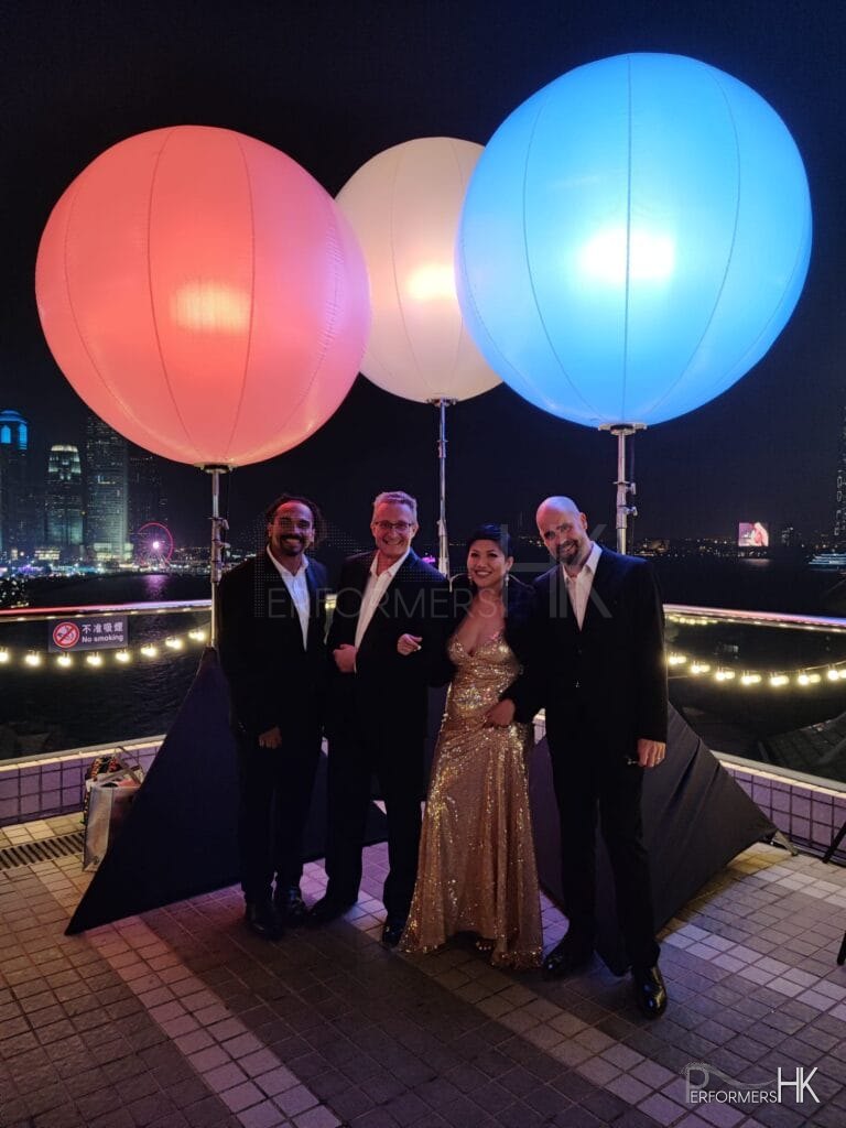 3 musicians and 1 singer at hk convention centre in 2023. Men in black suit and lady in gold dress