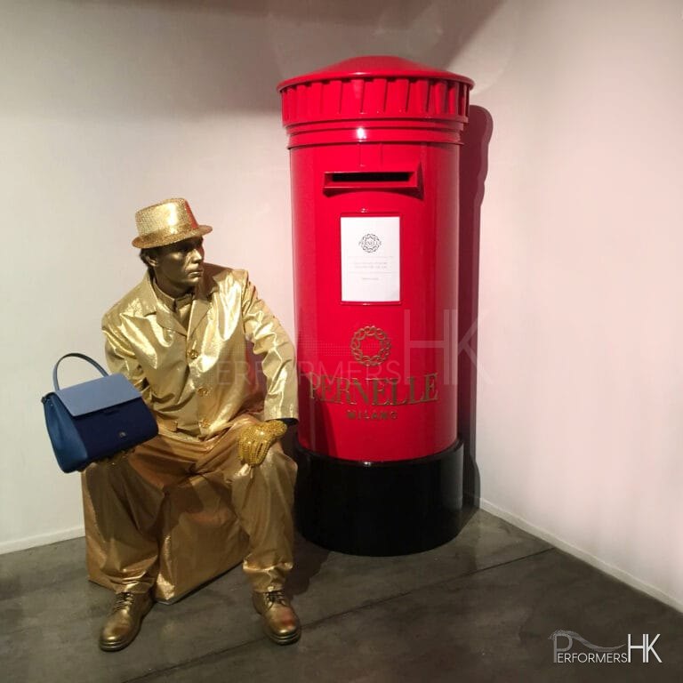 Living Statue holding handbag sitting next to red post box in hong kong