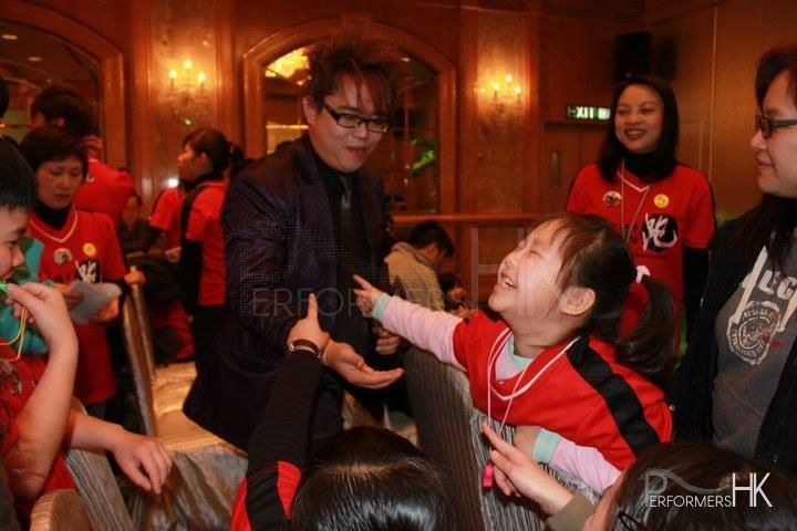 Magician in Hong Kong doing roving magic to impress a little audience at a Hong Kong Marathon event